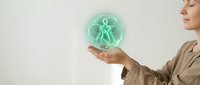 Woman holding glowing green holographic human figure symbol representing healthcare technology, medical innovation and digital wellness solutions.