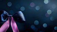 Elegant navy blue and pink satin ribbon bows against dark background with soft bokeh lights creating romantic festive atmosphere. Perfect for gift wrapping designs.