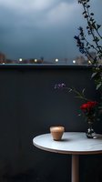 Cozy coffee cup with latte art on marble table at dusk, purple wildflowers in vase, bokeh city lights in background create romantic evening atmosphere.