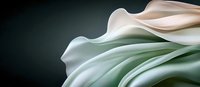 Elegant abstract macro photography of white and mint green flowing fabric or petals creating smooth curves and waves against dark background.