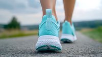 Close up view of turquoise running shoes on asphalt road during morning jog, white sole and mesh texture detail, active lifestyle and fitness concept.