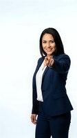 Confident Hispanic businesswoman in navy suit pointing forward with finger on white background for corporate marketing materials.