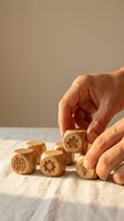 Hands arranging wooden cubes with innovation symbols including brain, gear, and lightbulb on rustic table for business strategy and creative thinking.