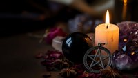 Mystical altar setup with burning candle, pentagram symbol, crystals and ritual elements for spiritual practices and occult ceremonies.