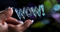 Magical glowing blue sparkly WOW text floating above fingers against dark background with bokeh lights. Creative typography and light painting concept for social media.