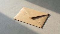 Kraft paper envelope on neutral surface with natural shadow lighting for correspondence and mailing designs.