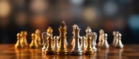 Chess pieces arranged on wooden board with golden and silver metallic finish in strategic game position for business concept and competition.