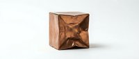 Copper metallic geometric cube with twisted angular faceted surface creating dimensional sculptural form on white background for modern design projects.
