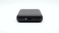 Compact black portable power bank with USB charging port and LED indicator light, isolated on white background for product design and e-commerce use.