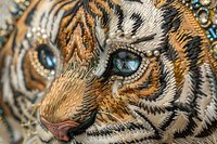 Ornate golden tiger face with intricate metallic patterns and jeweled blue eye details for luxury design projects and decorative artwork applications.