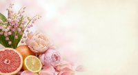 Spring floral arrangement with lily of valley, peonies, citrus fruits and pink ribbon on soft pastel background for greeting cards and romantic designs.