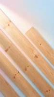 Natural wood planks arranged diagonally with soft pastel gradient lighting for modern interior design and construction projects.