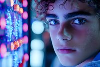 Close up portrait of young person with curly dark hair against blurred neon lights and bokeh background creating dreamy atmospheric mood for creative projects.