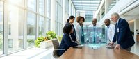 Diverse business team collaborating around conference table in modern glass office building with natural light and urban views.