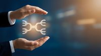 Businessman hands protecting white gear icons symbolizing teamwork, collaboration and business process management in corporate environment.