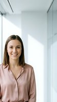Young professional woman smiling confidently in modern office environment wearing casual business attire for corporate workplace and career success.