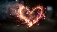 Sparkling heart-shaped sparkler creating magical light trails against dark background with glowing particles and bokeh effects for romantic celebrations.