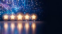 Five golden stars glowing on reflective surface with blue bokeh lights background for rating, review, quality assessment and customer feedback concepts.