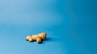 Soft plush teddy bear lying on side against vibrant blue background, isolated product photography for commercial and retail marketing use.