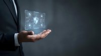 Businessman in dark suit holding glowing digital security shield with lock icons, representing cybersecurity, data protection, and network safety solutions for business.