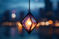 Glowing geometric pendant lamp with warm light against blurred city bokeh background in twilight blue tones creates magical ambiance for design projects.