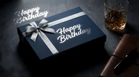 Elegant navy blue Happy Birthday gift box with silver ribbon, whiskey glass and leather accessory on dark background, masculine celebration concept.