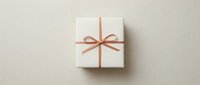 White gift box with elegant pink ribbon bow on neutral beige background for special occasions, holidays, birthdays, celebrations and present giving concepts.