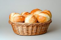 Fresh baked bread rolls in wicker basket on neutral background for bakery menu design and food photography projects.