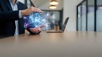 Businessman holding glowing network connections hologram above hands in modern office workspace representing digital transformation and connectivity solutions.
