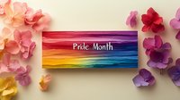 Rainbow colored brush strokes with Pride Month text on wooden sign decorated with pink and purple paper flowers on white background.