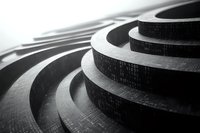 Abstract curved architectural steps forming concentric circles in dramatic black and white lighting, creating geometric patterns with strong shadows and depth.