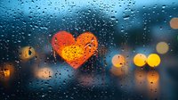 Heart shape drawn on rainy window glass with blurred city lights in background creating romantic atmosphere during evening downpour.