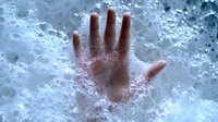 Human hand pressing against frosted glass surface with condensation and water droplets creating atmospheric moody effect. Suitable for concepts of isolation, winter, cold.