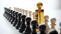 Golden king chess piece standing out among black and white pawns representing leadership strategy and business success concepts.