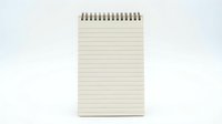 Blank lined spiral notepad with cream pages and metal binding isolated on white background for writing notes and planning tasks.