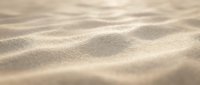 Soft golden sand dunes with gentle waves and ripples creating natural texture patterns under warm sunlight for desert landscape backgrounds.