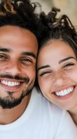 Close up portrait of young diverse couple smiling with white teeth. Mixed race man with beard and woman with freckles showing genuine happiness and joy.