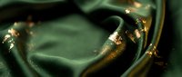 Abstract green and gold liquid metal surface with flowing waves and metallic reflections creating luxurious background for premium design projects.