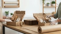 Eco-friendly packaging materials with kraft paper boxes, brown wrapping paper and natural twine for sustainable shipping and gift wrapping solutions.