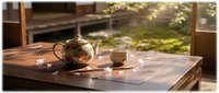 Glass teapot with herbal tea and cup on wooden table in sunlit garden setting creating peaceful afternoon atmosphere for relaxation and mindfulness.