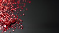 Red glitter heart with scattered sparkly confetti on dark background, romantic holiday decoration for Valentine's Day cards and romantic designs.
