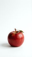 Fresh red apple with green leaf isolated on white background for healthy eating and nutrition concepts.