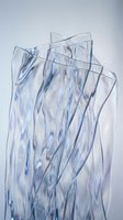 Abstract transparent glass shards with flowing organic curves and blue tints creating modern artistic composition for contemporary design projects.
