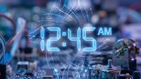 Digital clock display showing 12:45 AM with glowing blue numbers and light effects over electronic circuit board background for technology concepts.