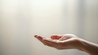 Open cupped hands in gentle receiving gesture against soft blurred background suggesting hope, prayer, support and spiritual connection for wellness concepts.