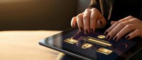 Professional woman using secure digital tablet with golden security icons for business technology and data protection applications.