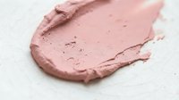 Smudged rose pink cosmetic powder or blush swatch on white background, suitable for beauty, makeup, and skincare product marketing.