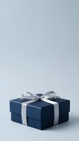 Dark blue gift box with silver ribbon bow on neutral background, suitable for holiday, birthday, and celebration marketing materials.