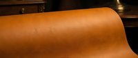 Rolled cognac leather material with smooth texture and warm tone, suitable for upholstery, fashion design, and interior decoration projects.