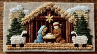 Embroidered nativity scene with holy family in wooden manger, surrounded by sheep and evergreen trees against rustic fabric background. Traditional Christmas needlework design.